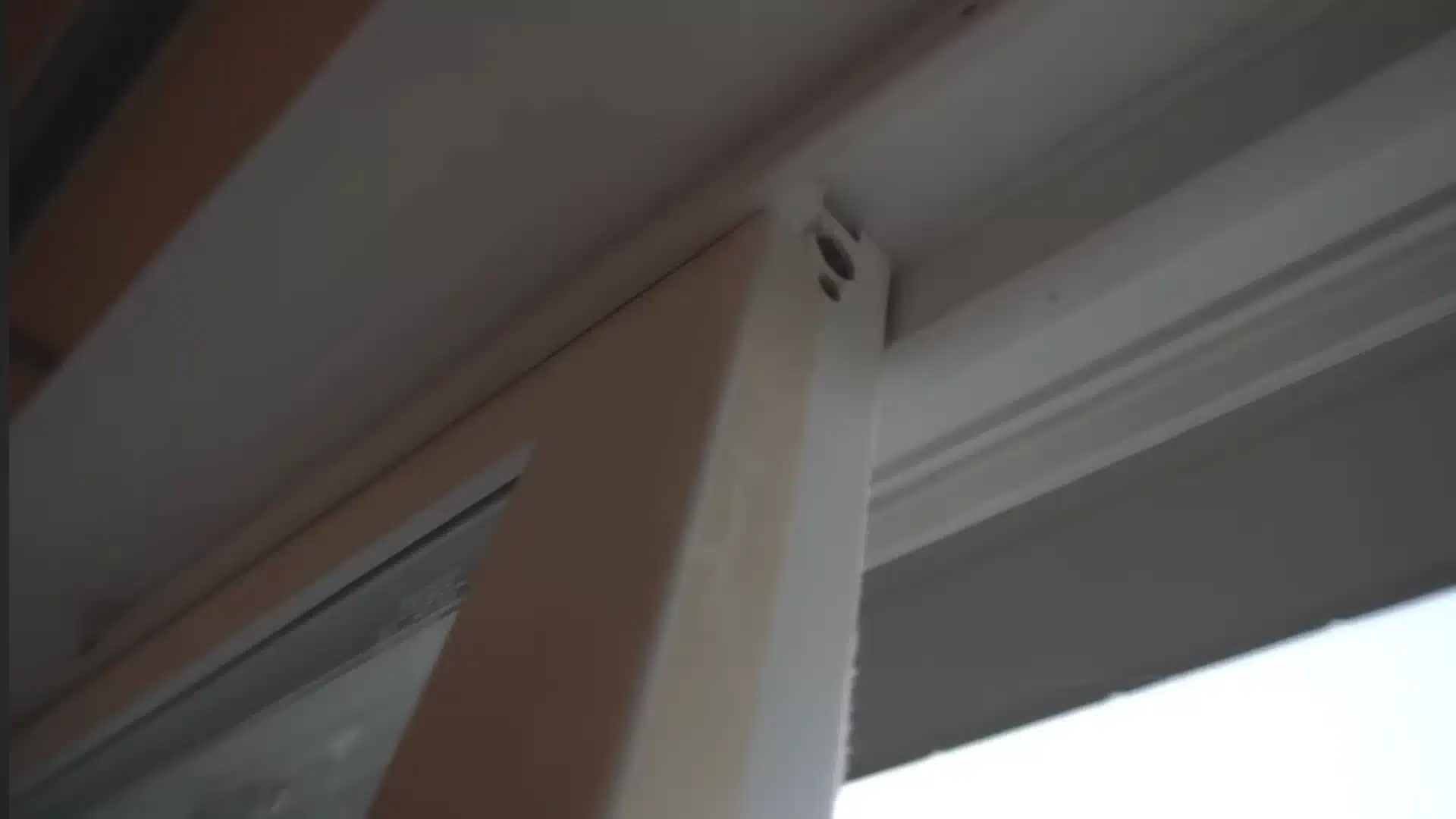 Close-up of a white sliding door frame fitted into the top track in