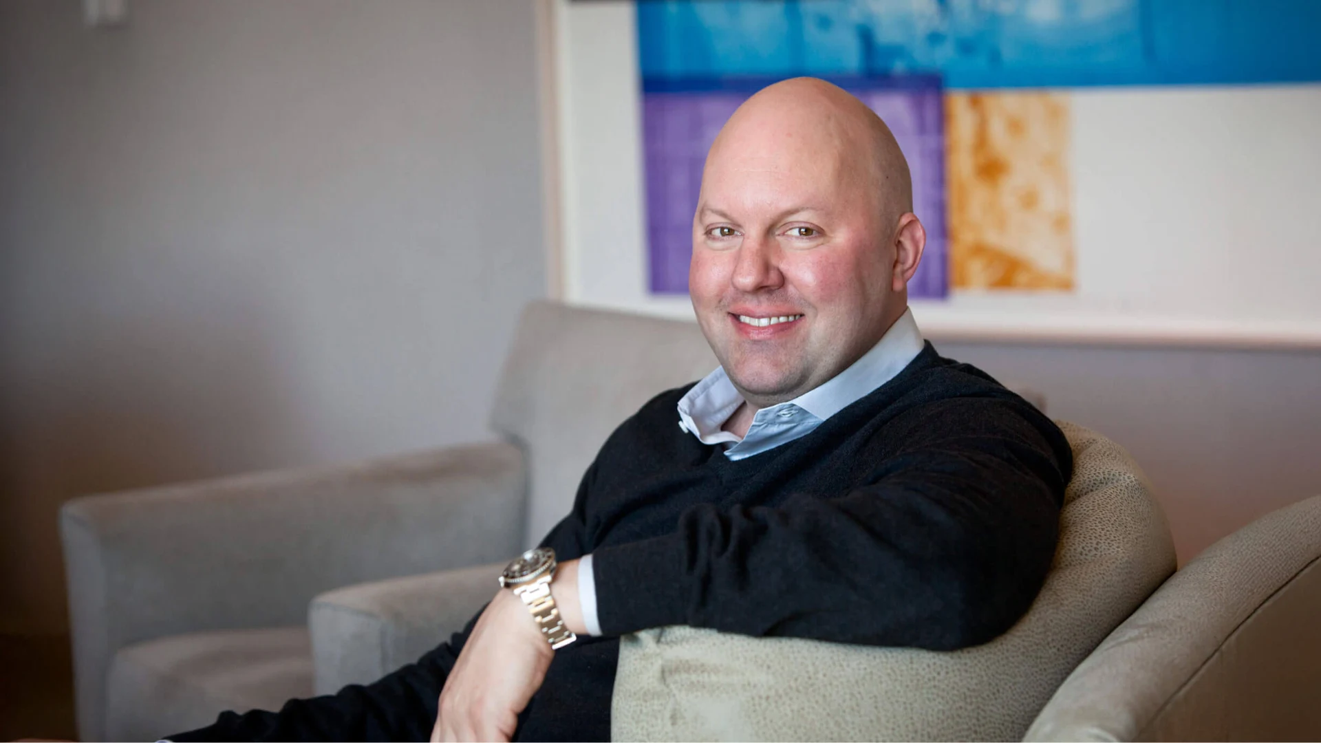 Marc Andreessen seated in an office chair with modern wall art in the background