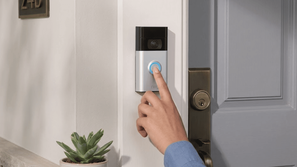 person pressing illuminated ring video doorbell button beside a residential front door with modern home entrance setting
