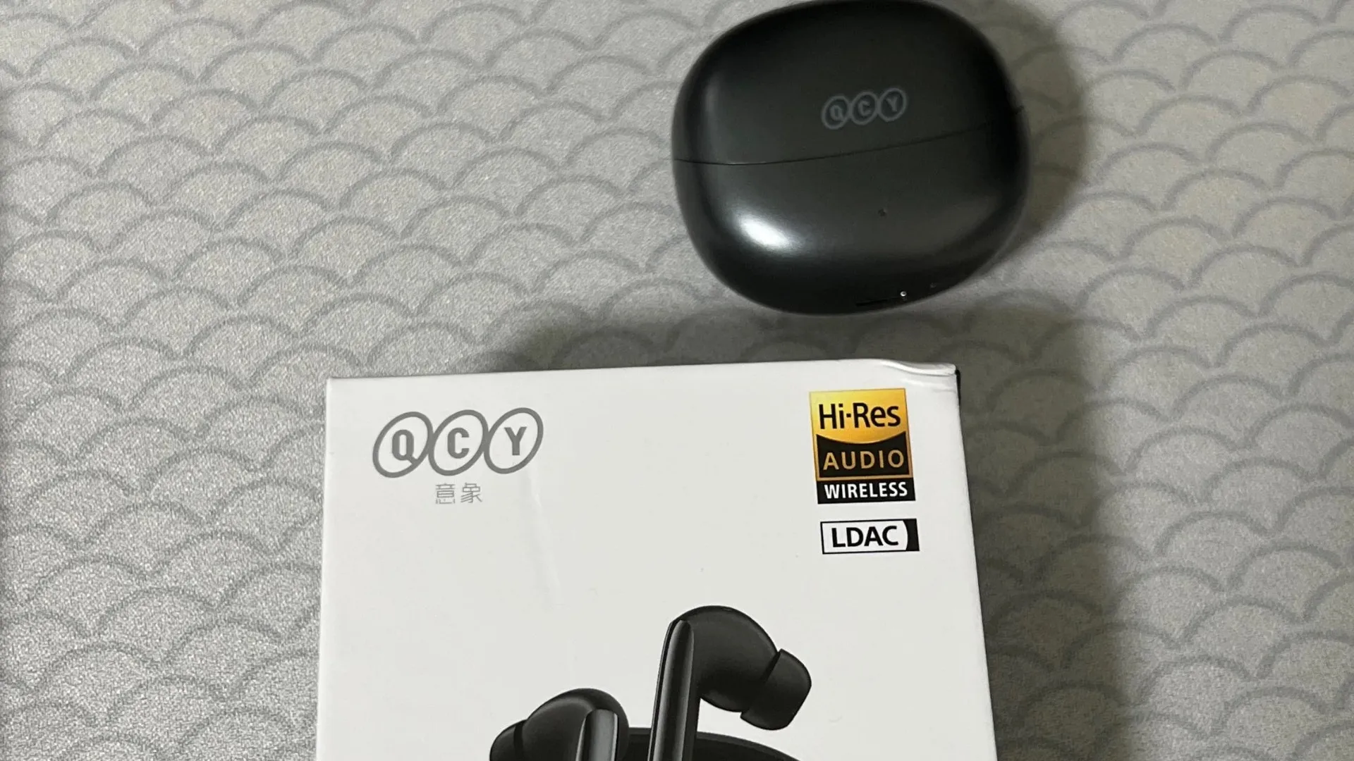 QCY MeloBuds Pro charging case placed above the product box showing Hi-Res Audio and LDAC labels