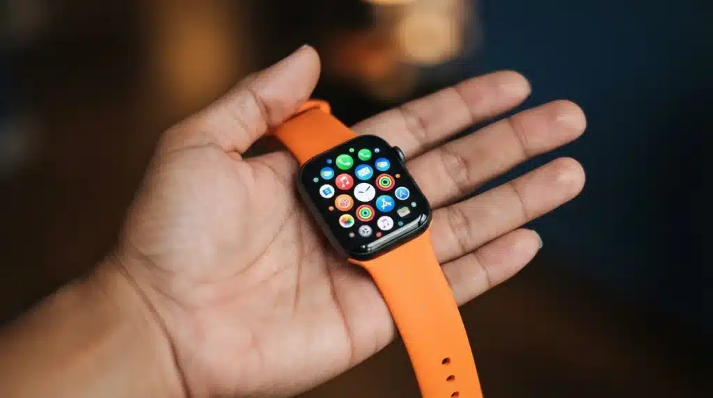 apple watch displaying a game beside iphone app store with gaming options on desk