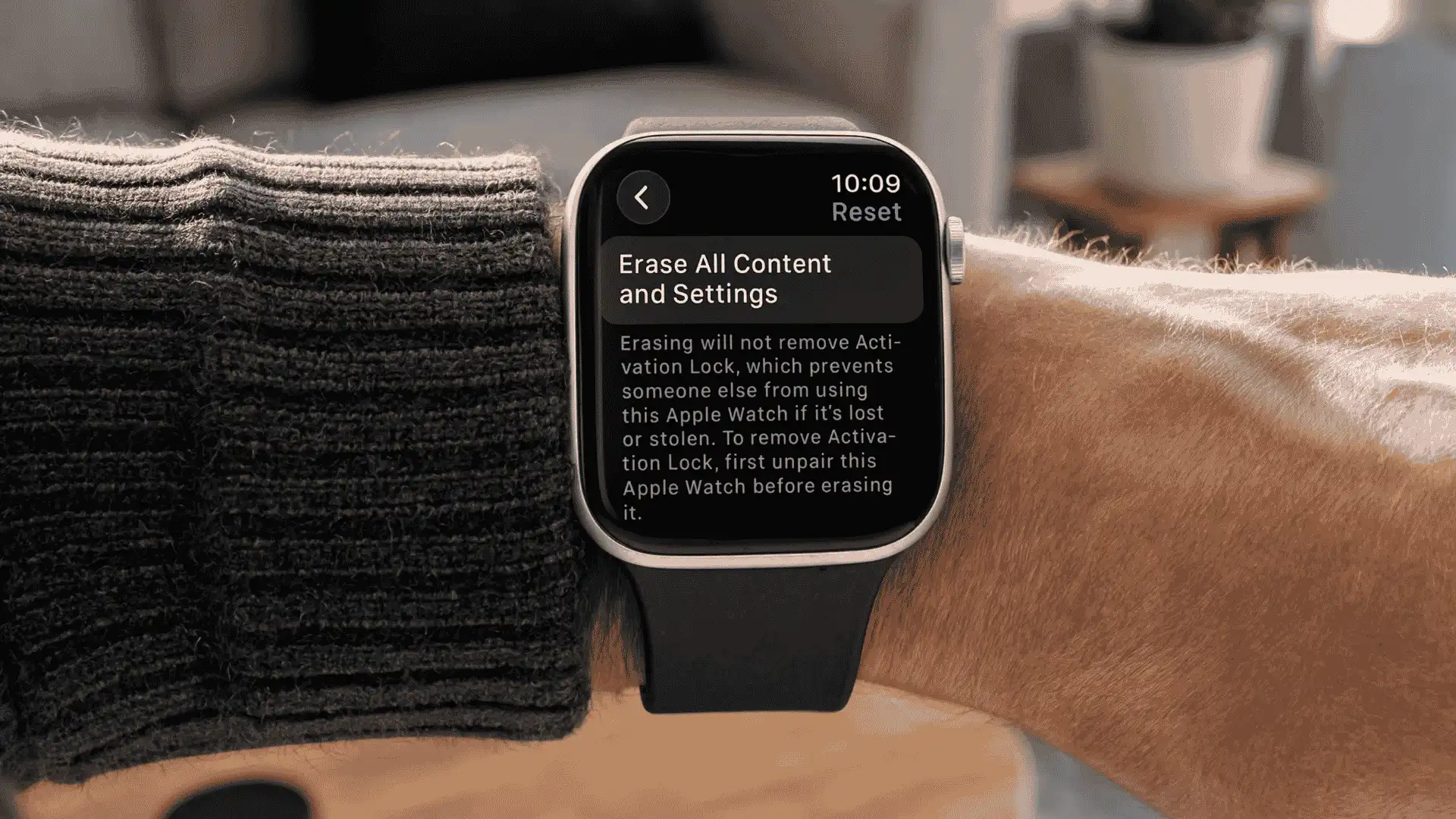 Apple Watch on a wrist showing the erase all content and settings reset screen with Activation Lock warning