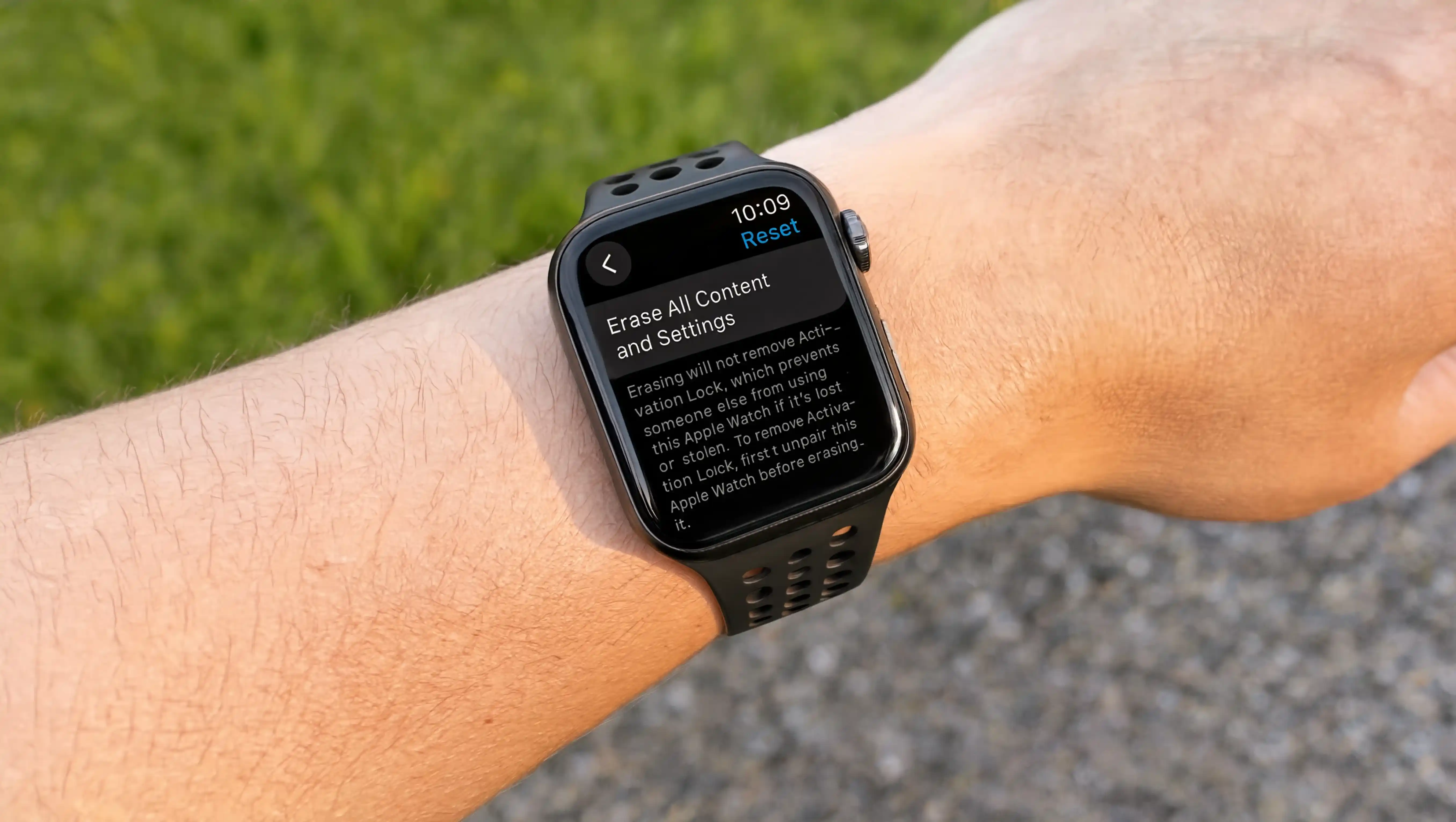 Apple Watch with black band showing Erase All Content and Settings screen