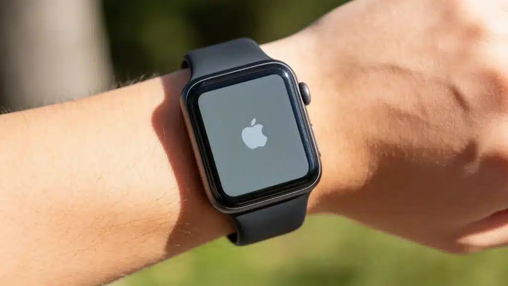 Apple Watch worn on wrist outdoors with visible Apple logo on screen