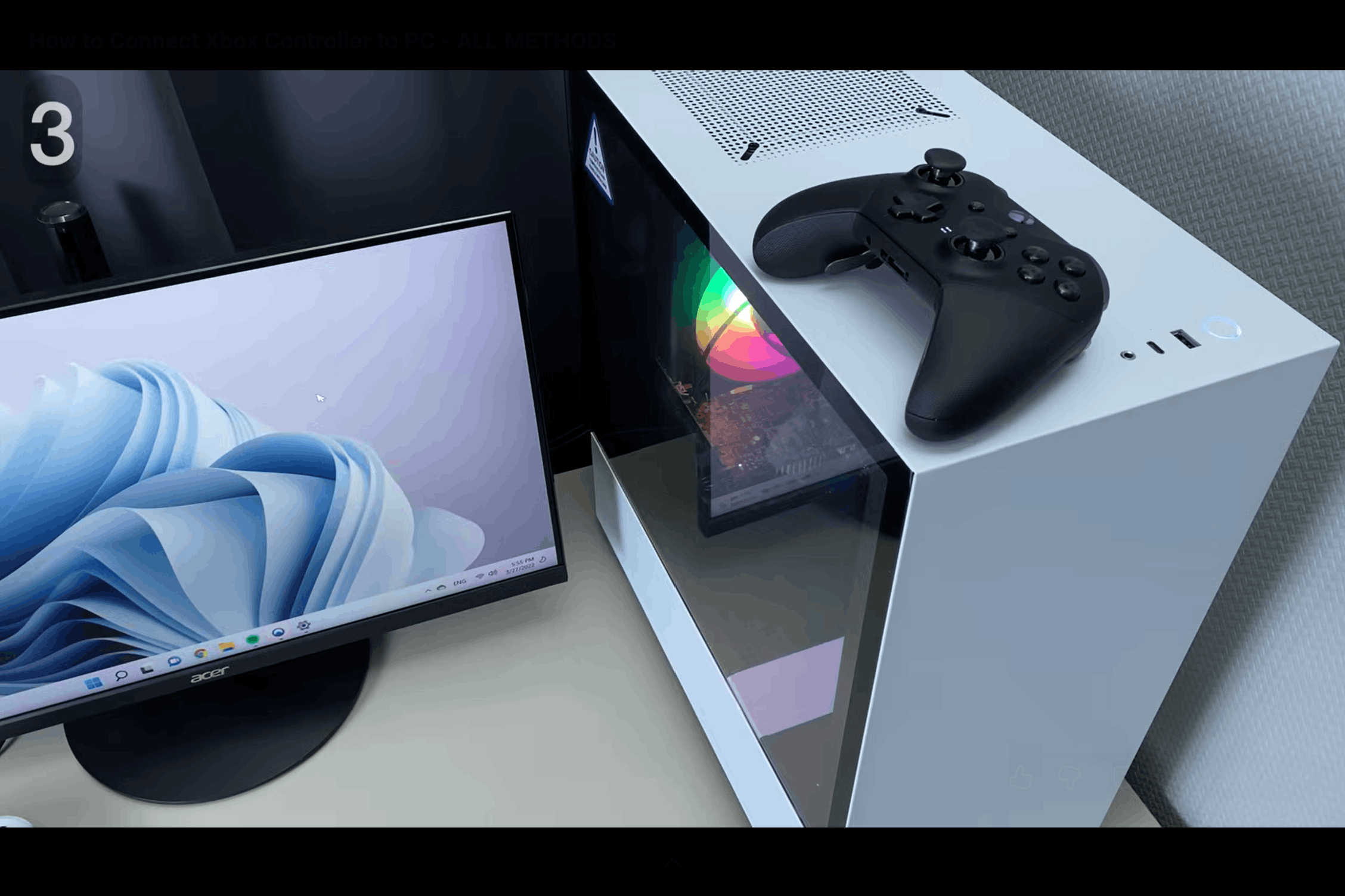 black xbox controller resting on top of a desktop pc beside a monitor after completing the wireless connection setup