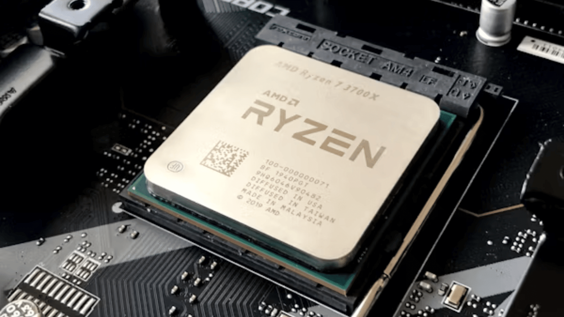 close up of an amd ryzen processor installed in a motherboard socket surrounded by electronic components and circuitry
