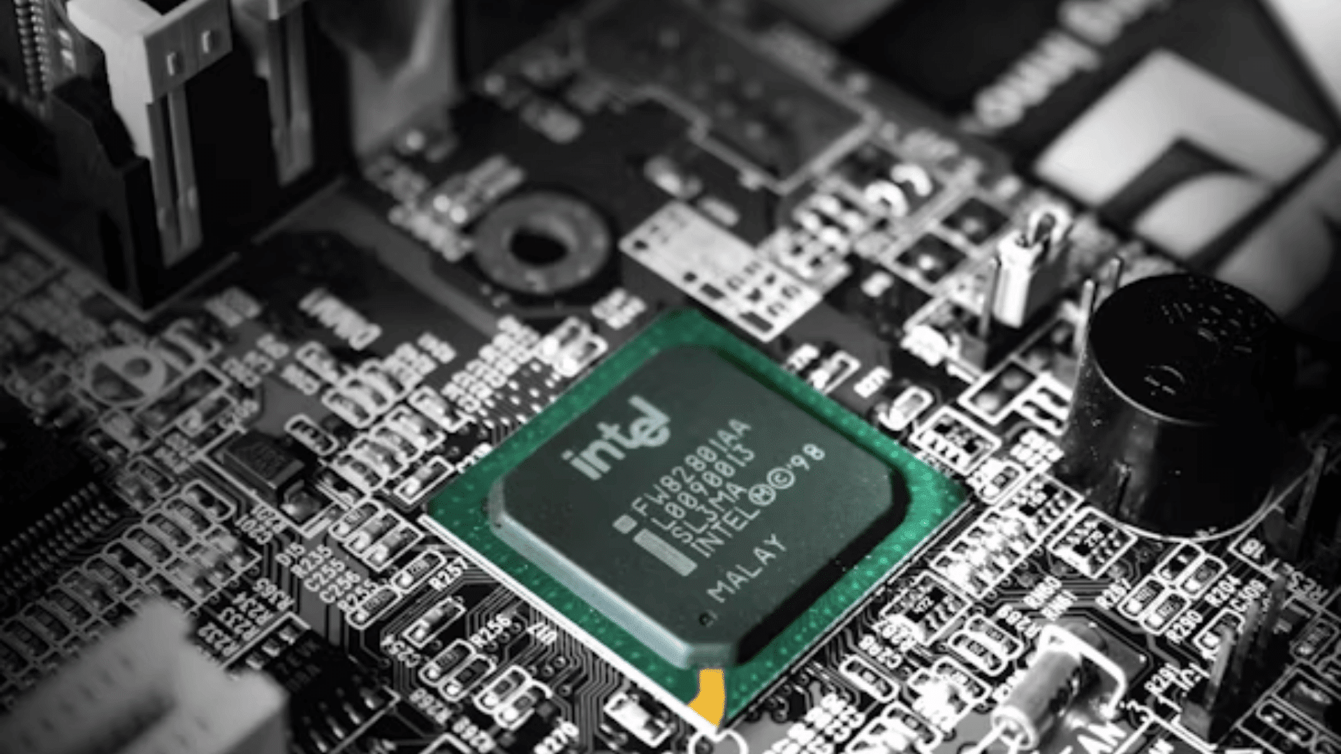 close up of an intel chipset mounted on a computer motherboard surrounded by electronic circuits connectors and components
