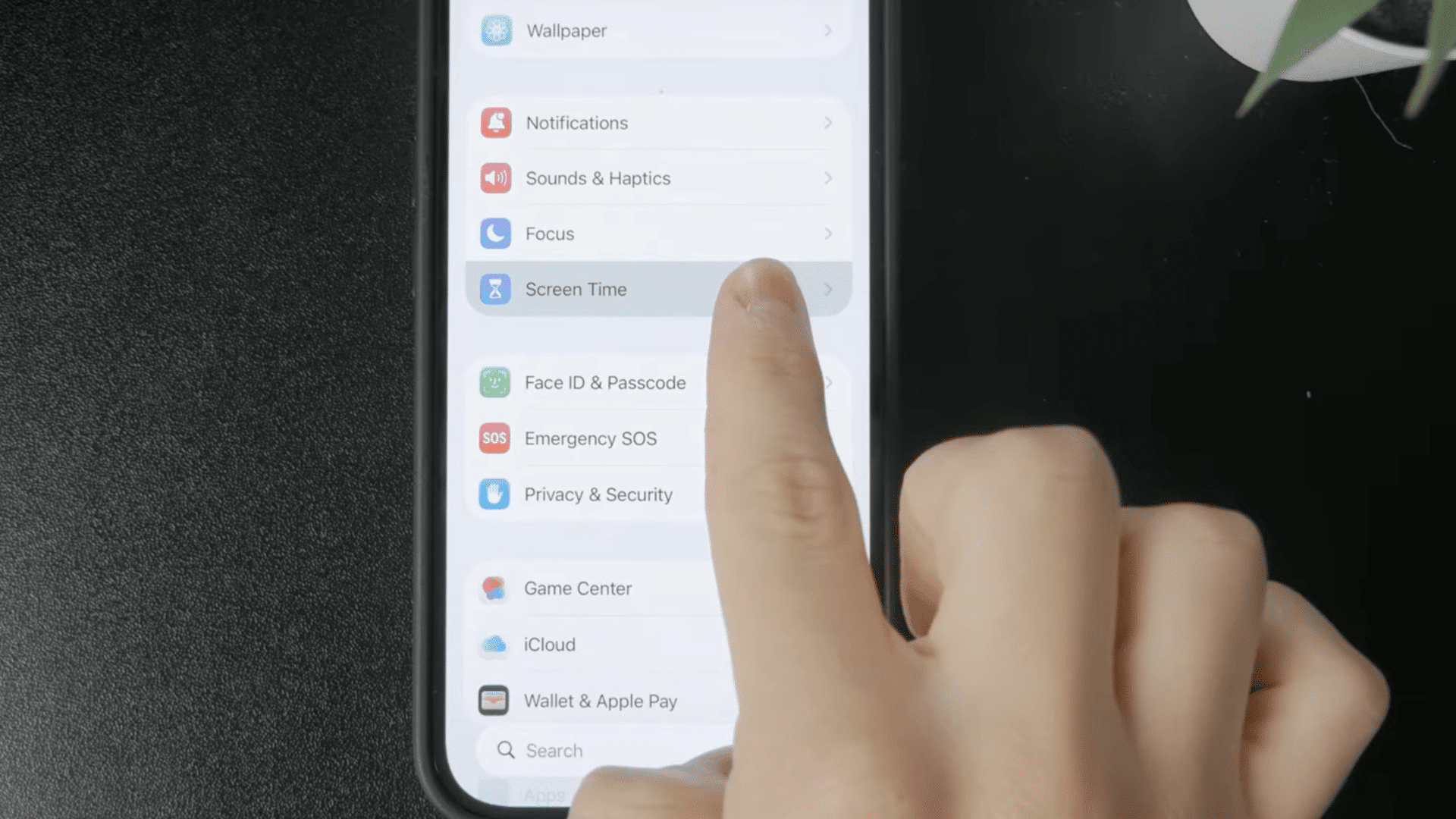 finger selecting screen time in iphone settings to manage device usage and parental control options