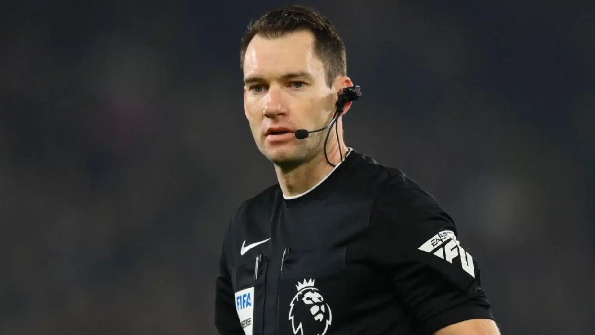 Football referee wearing headset and body camera during a match