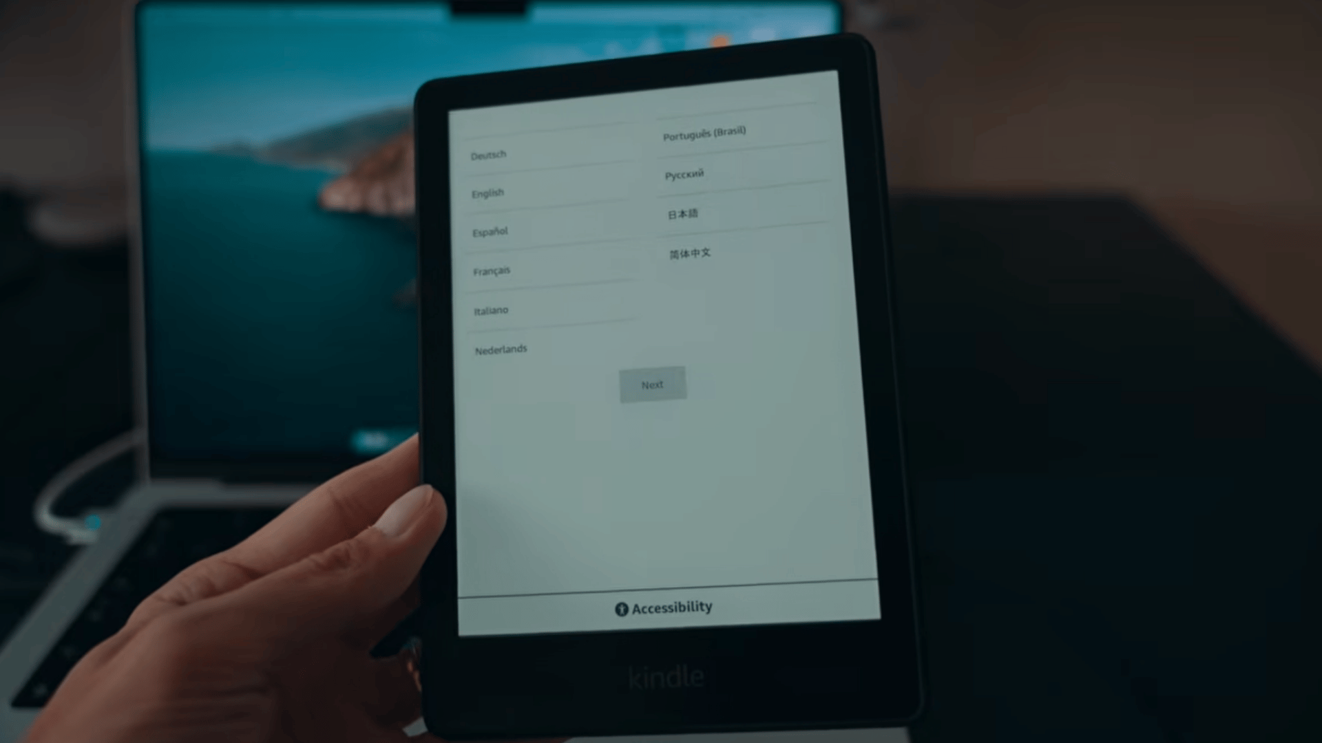 hand holding a kindle ereader displaying the language selection screen during initial device setup