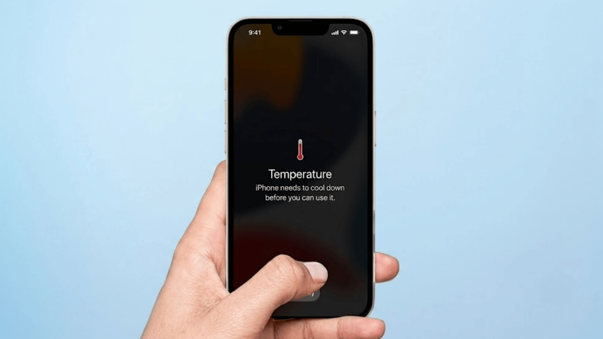 hand holding iphone displaying temperature warning saying iphone needs to cool down before it can be used on blue background