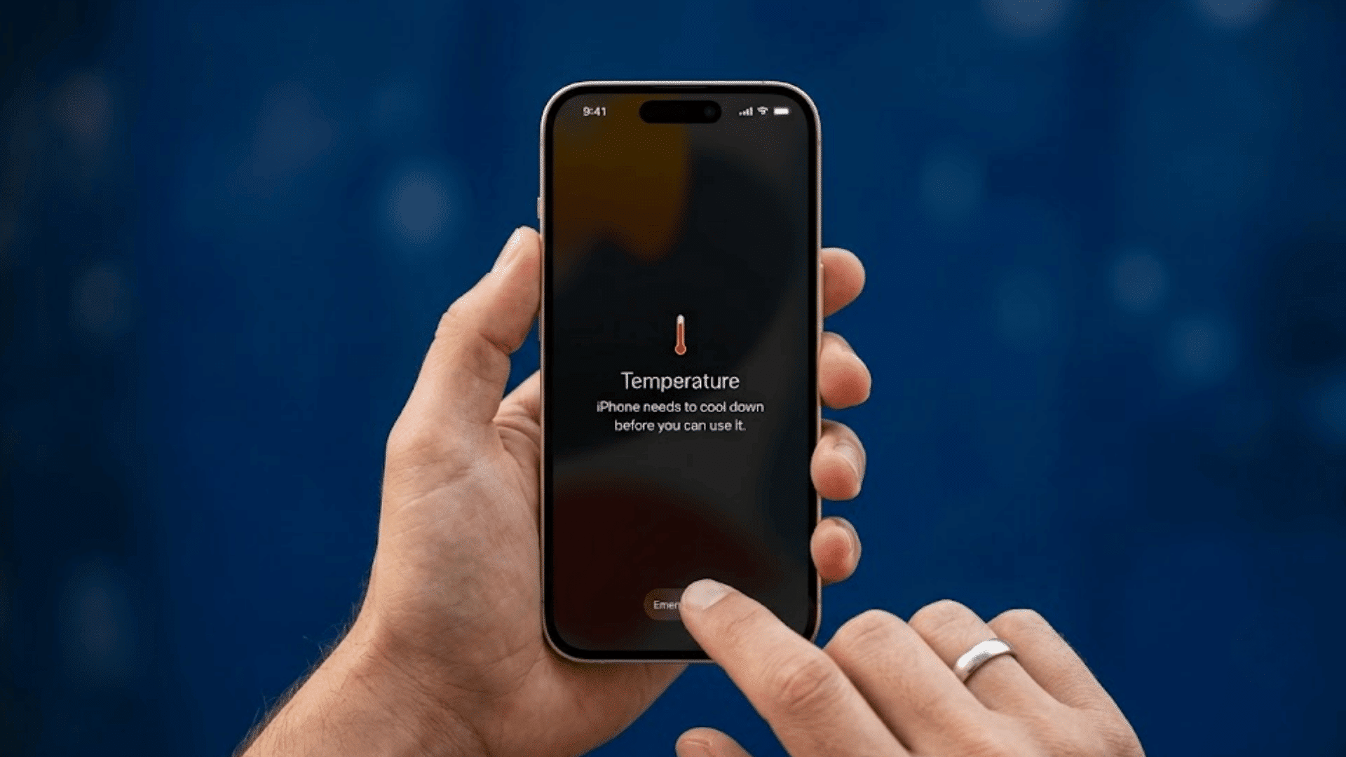 hand holding iphone showing temperature warning while another finger taps emergency button on the screen