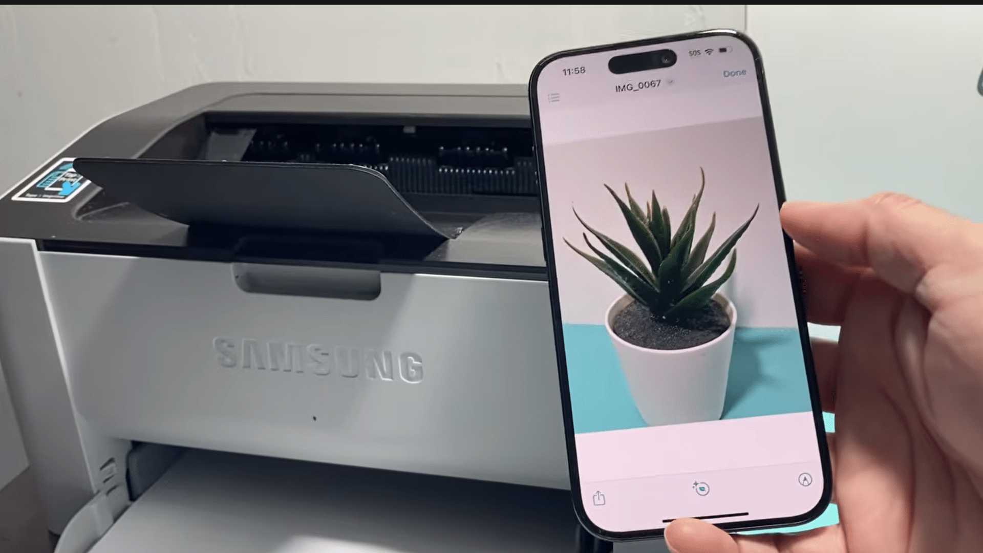 iphone displaying a photo beside a wireless samsung printer ready to print an image through a wireless connection