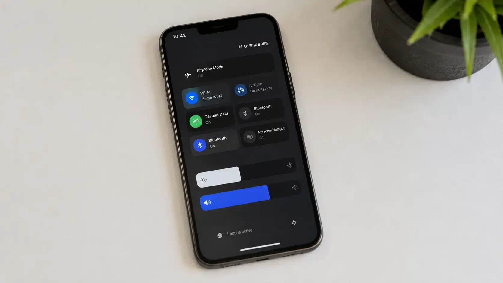 iphone lying flat on a desk displaying control center with one active background app and wireless settings enabled