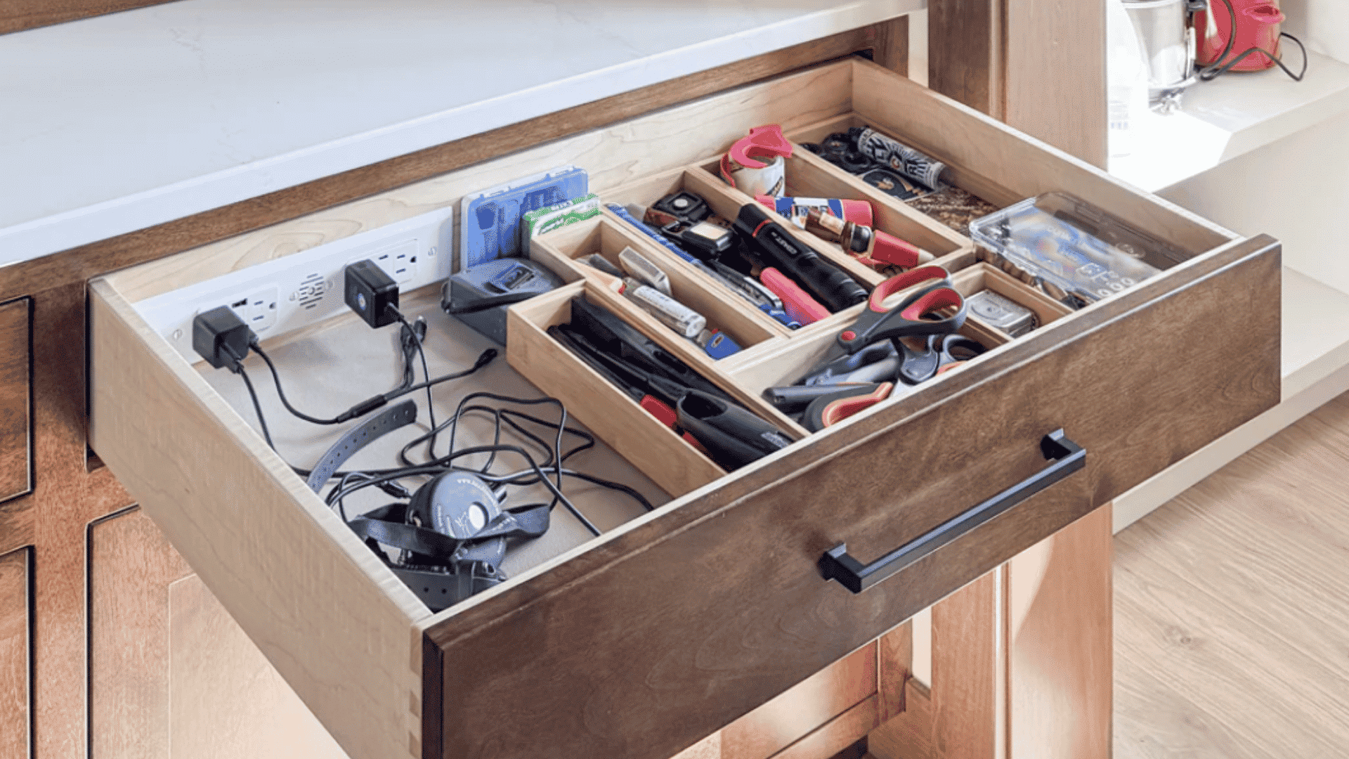 kitchen drawer with built in power outlets neatly organizing chargers cables tools and household accessories
