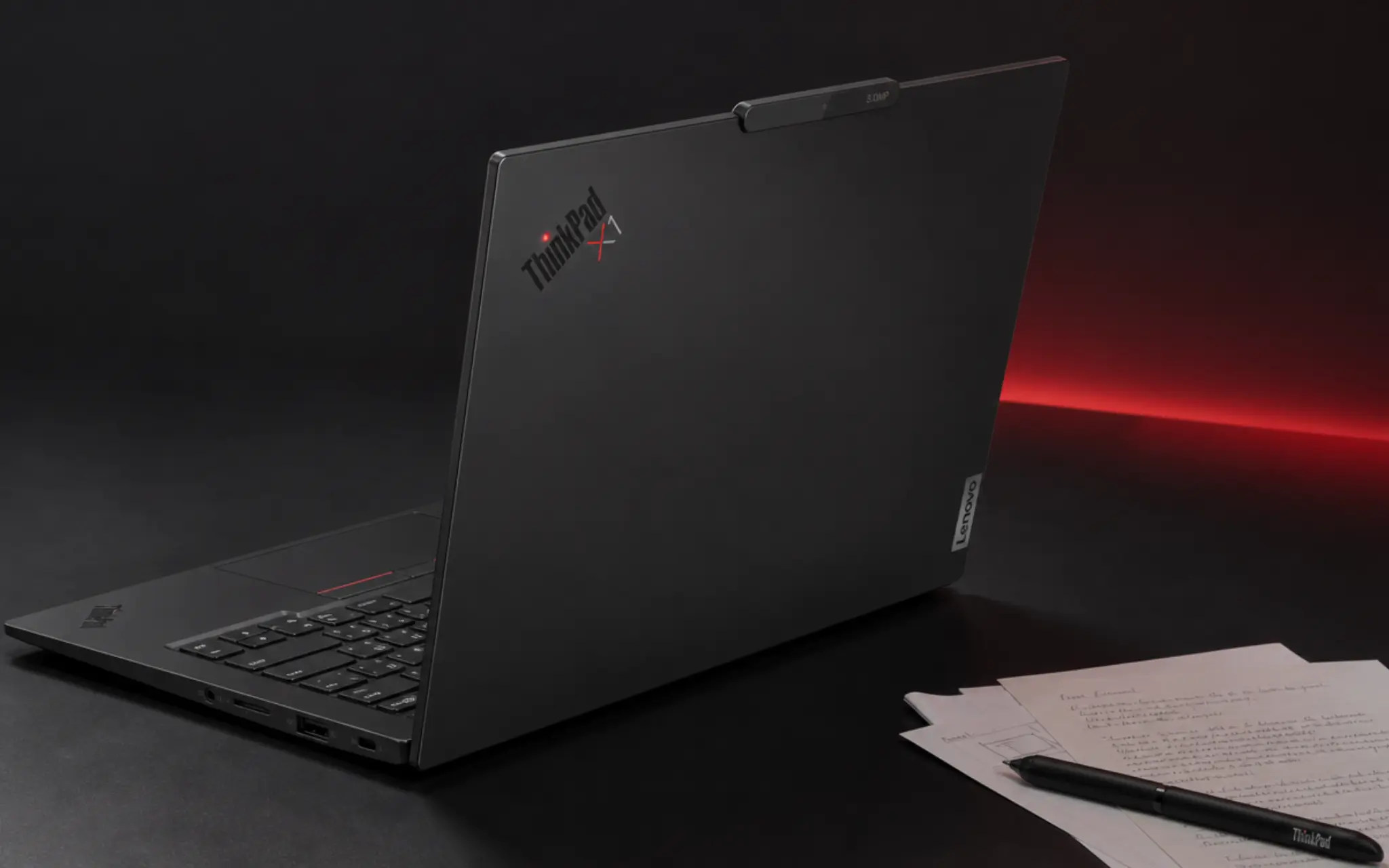 lenovo thinkpad x1 carbon gen 14 with red trackpoint and official logos on a dark studio background