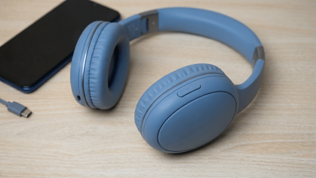 person resetting bluetooth headphones by holding the power button while the led light flashes for factory reset mode