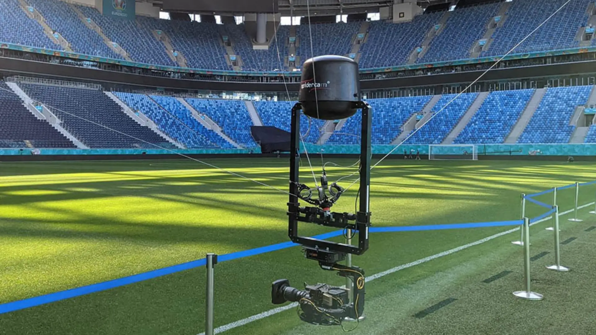 Spider camera suspended over a football pitch inside an empty stadium