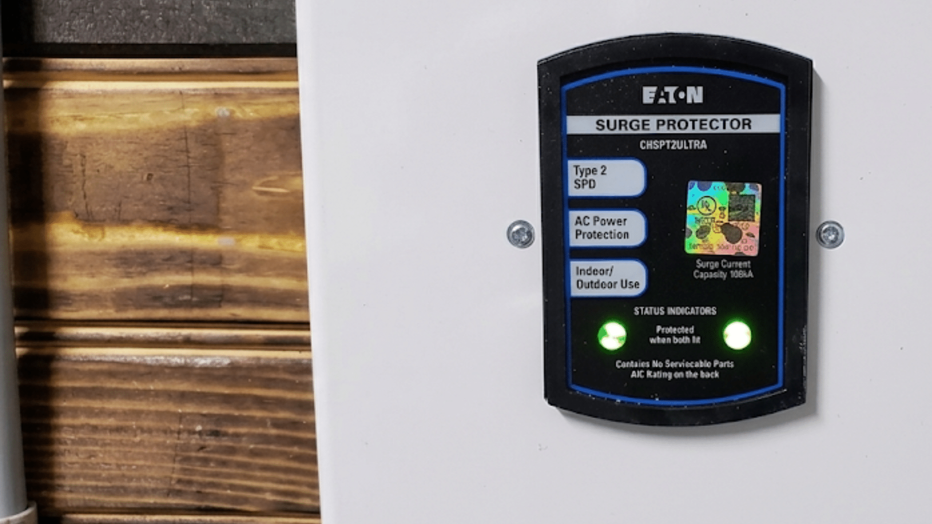 surge protector mounted on a wall with illuminated status lights indicating active electrical protection