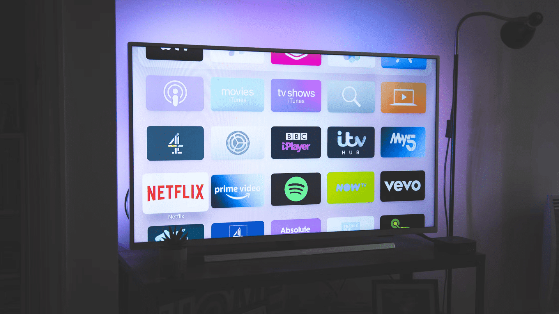 television on a media console displaying a music streaming app with vinyl records and a turntable beside it