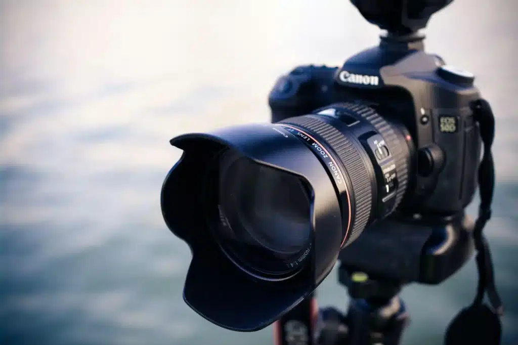 Close-up of a Canon DSLR camera with lens hood outdoors in soft lighting