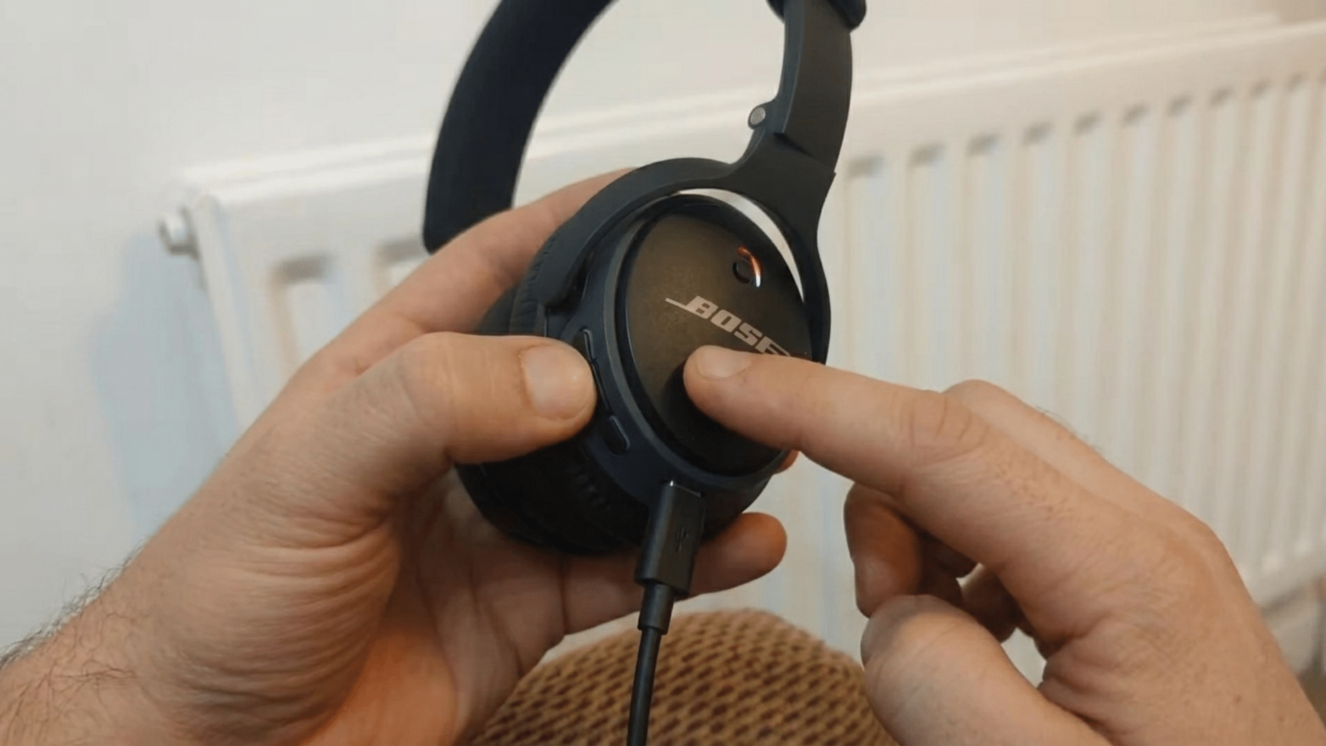 user pressing and holding the reset button on bluetooth headphones to restore factory settings and fix pairing issues