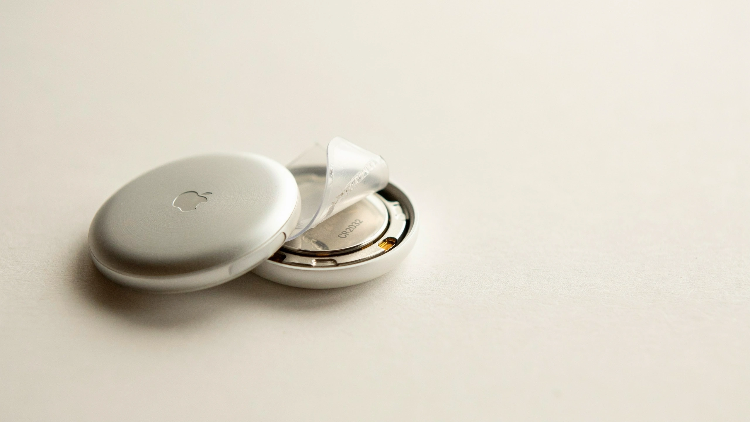 airtag opened showing battery compartment and cr2032 battery during replacement or reset process