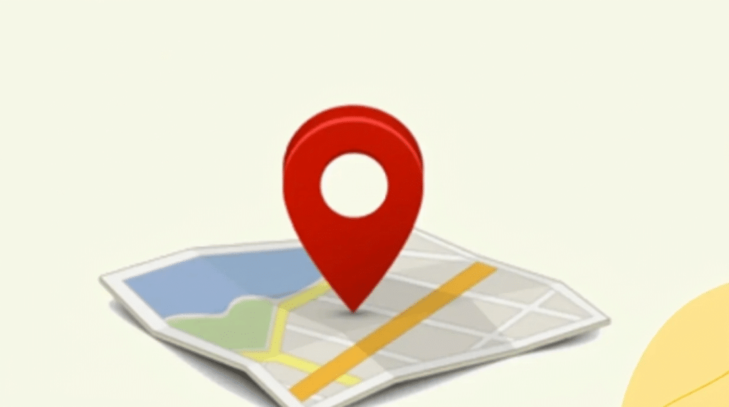 Red map pin marker dropped on a folded paper map illustrating how to drop a pin for location sharing
