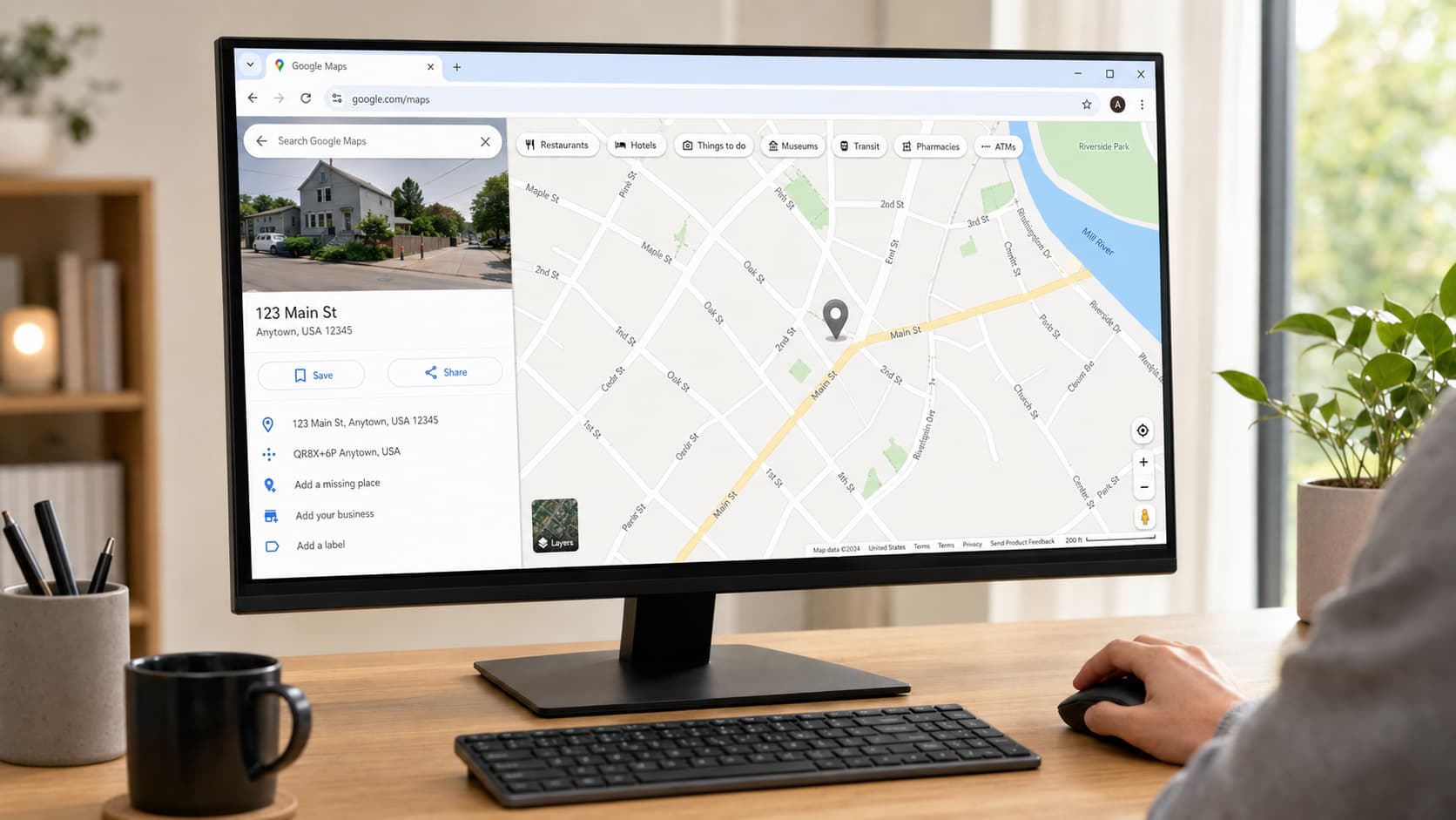 person using google maps on a desktop computer with a grey location pin and details panel open on screen