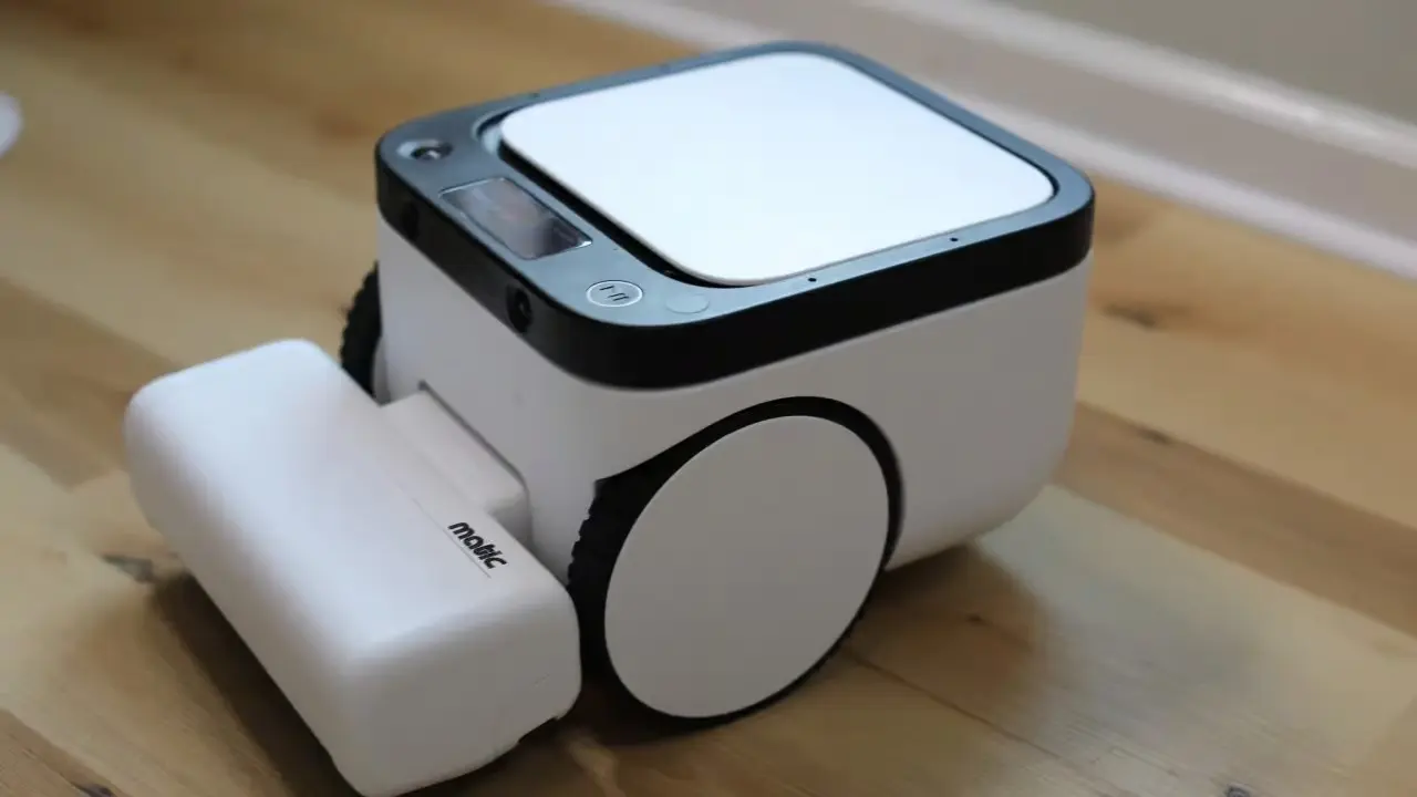 white matic robot vacuum with charging dock placed on wooden floor in a modern home setting