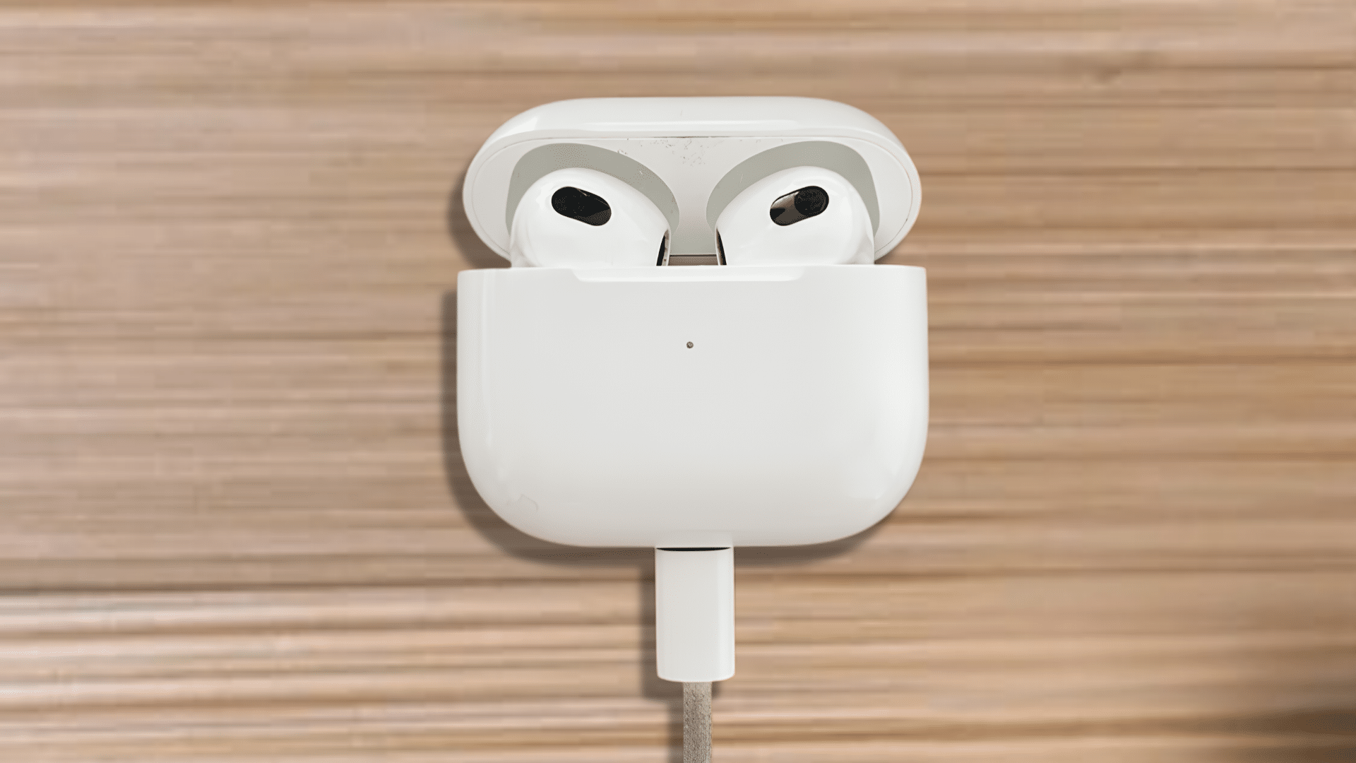 white airpods pro charging case open with both earbuds visible on a wooden surface