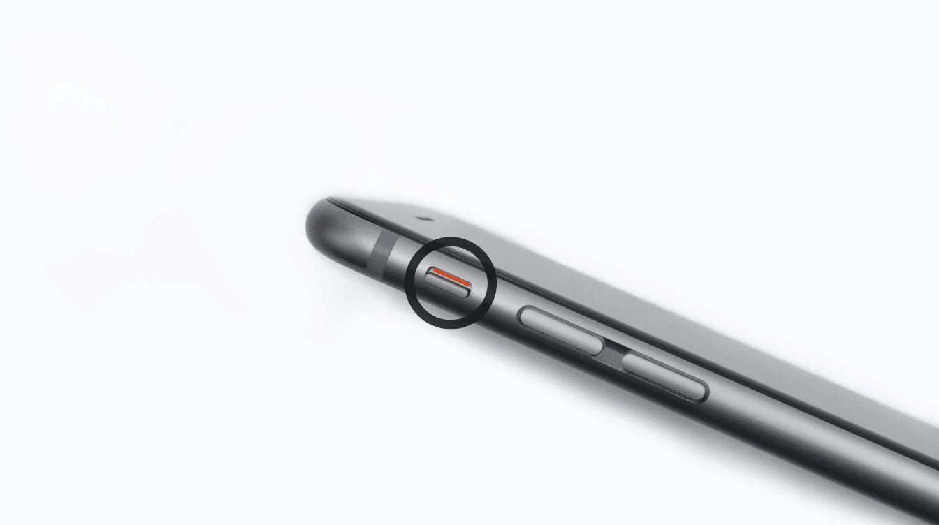 close-up of an iPhone ring/silent switch showing the orange indicator above the volume buttons.
