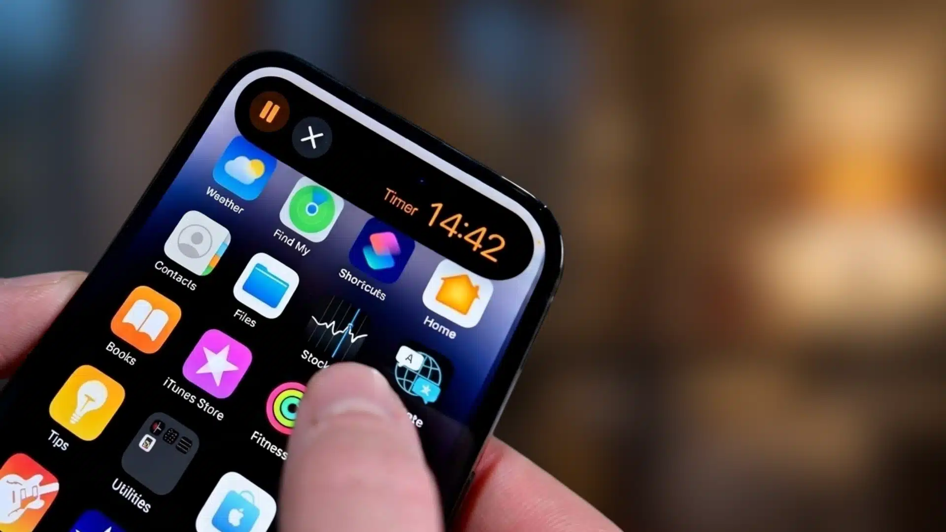 iphone screen showing dynamic island with an active timer and pause control above the home screen