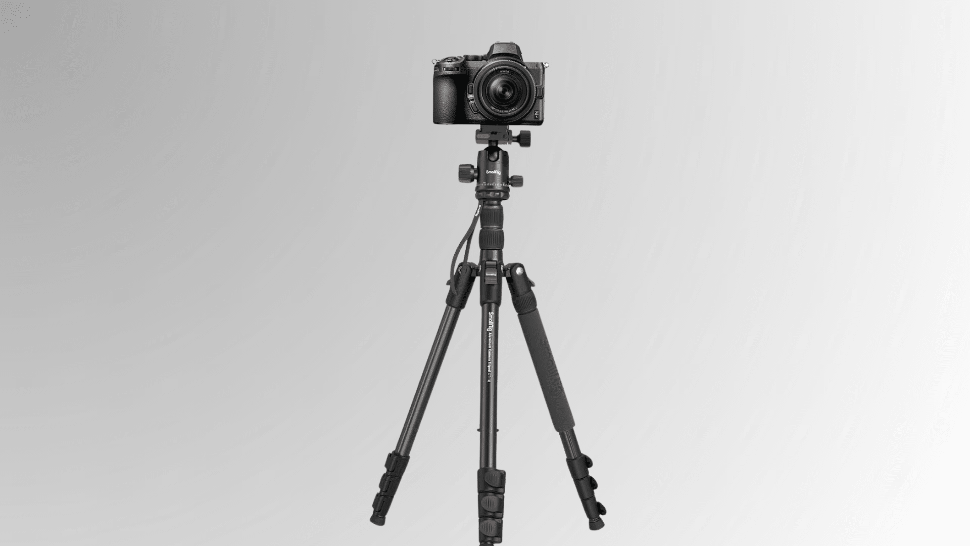 camera mounted on a tripod with extended center column and adjustable legs on white background