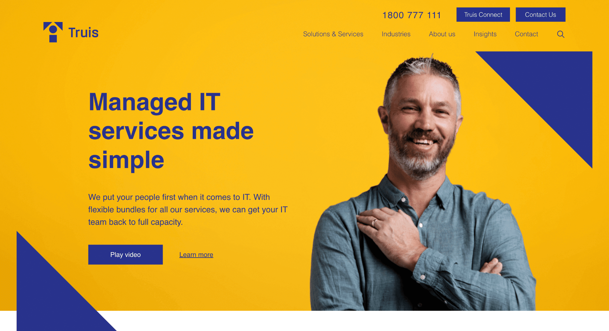 Smiling man in blue shirt against bright yellow background with geometric shapes